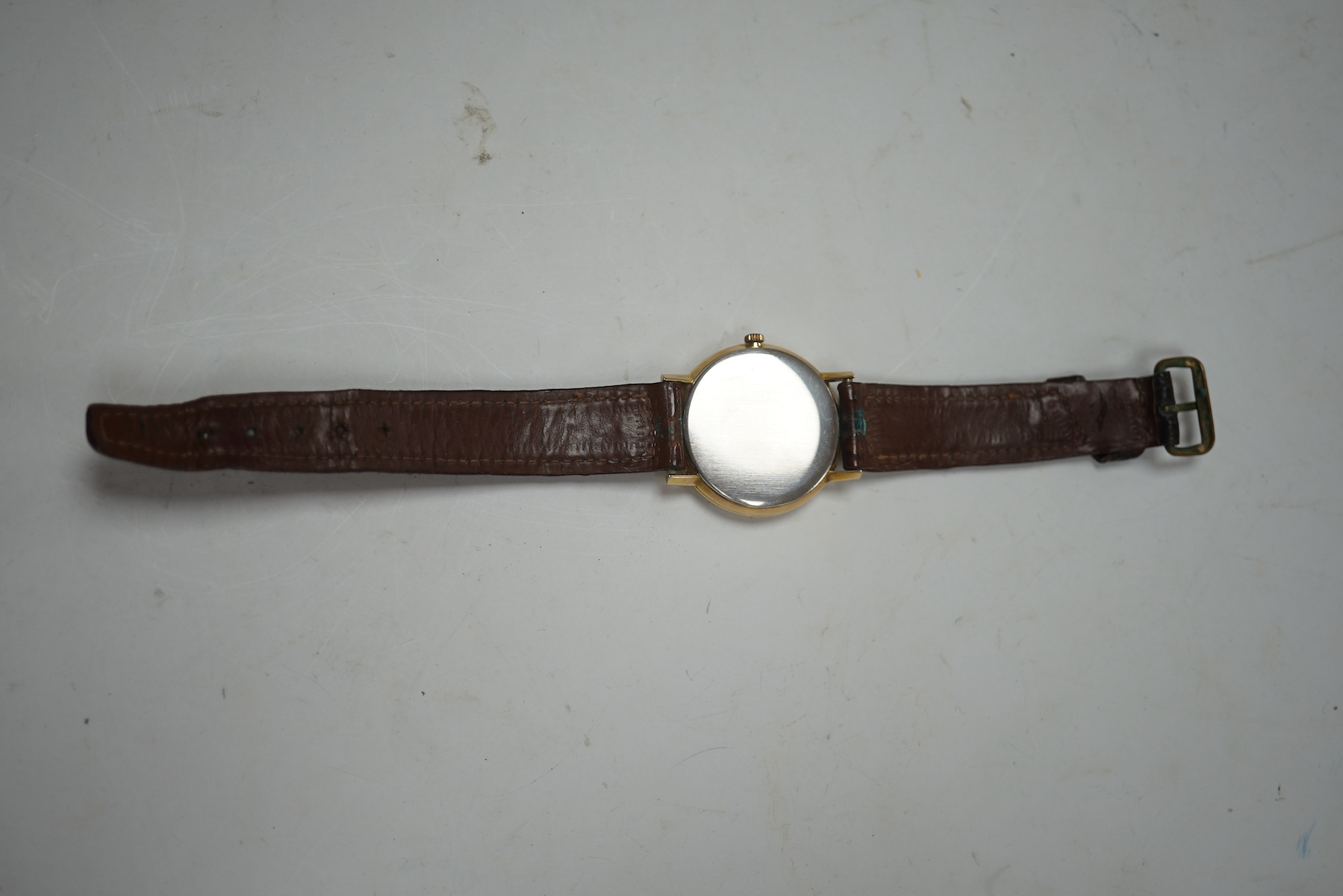 A gentleman's gold plated Omega manual wind wrist watch, on a leather strap, case diameter 34mm. Condition - Fair